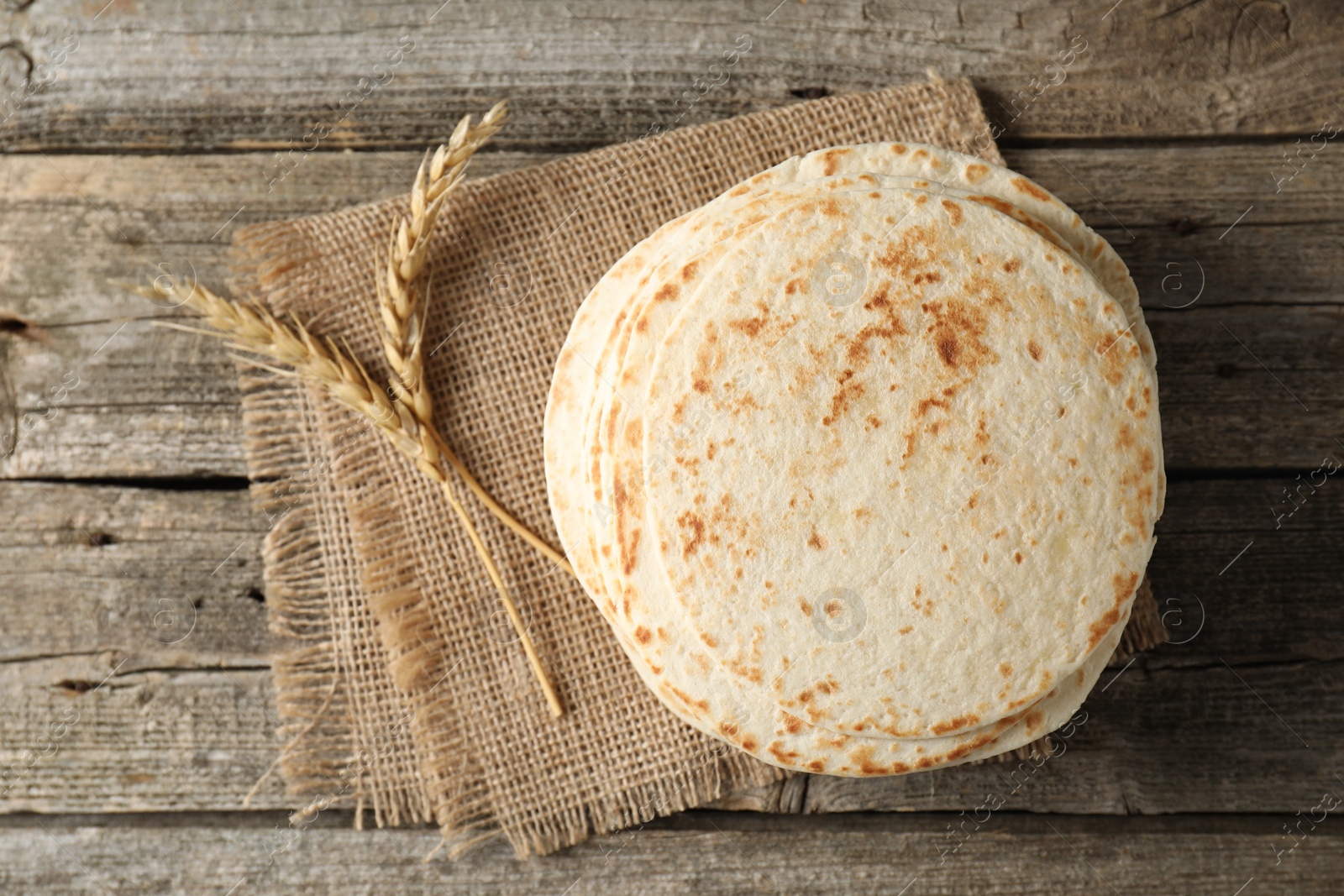 Photo of Tasty homemade tortillas and spikes on wooden table, top view