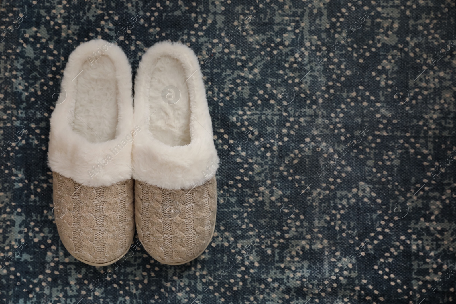 Photo of Pair of beautiful soft slippers on carpet, top view. Space for text