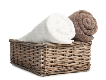 Rolled soft terry towels in wicker basket on white background