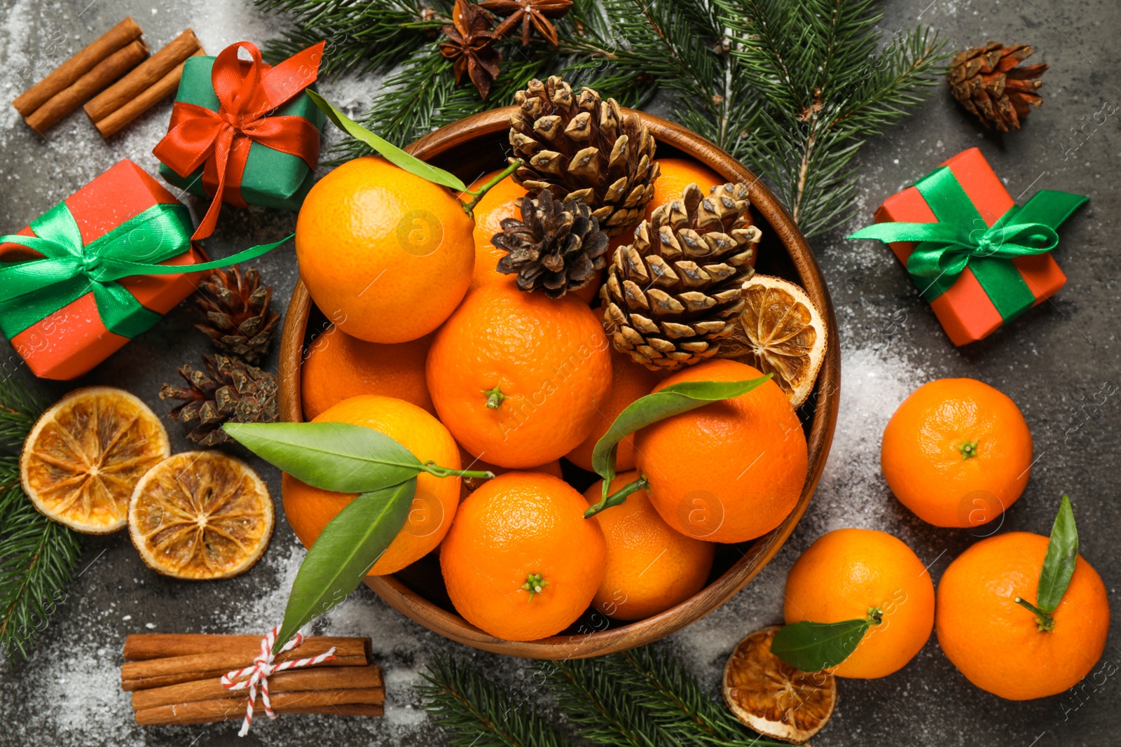 Photo of Christmas composition with fresh tangerines and gifts on grey background, flat lay