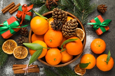 Photo of Christmas composition with fresh tangerines and gifts on grey background, flat lay