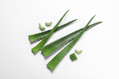 Photo of Cut aloe vera leaves on white background, flat lay