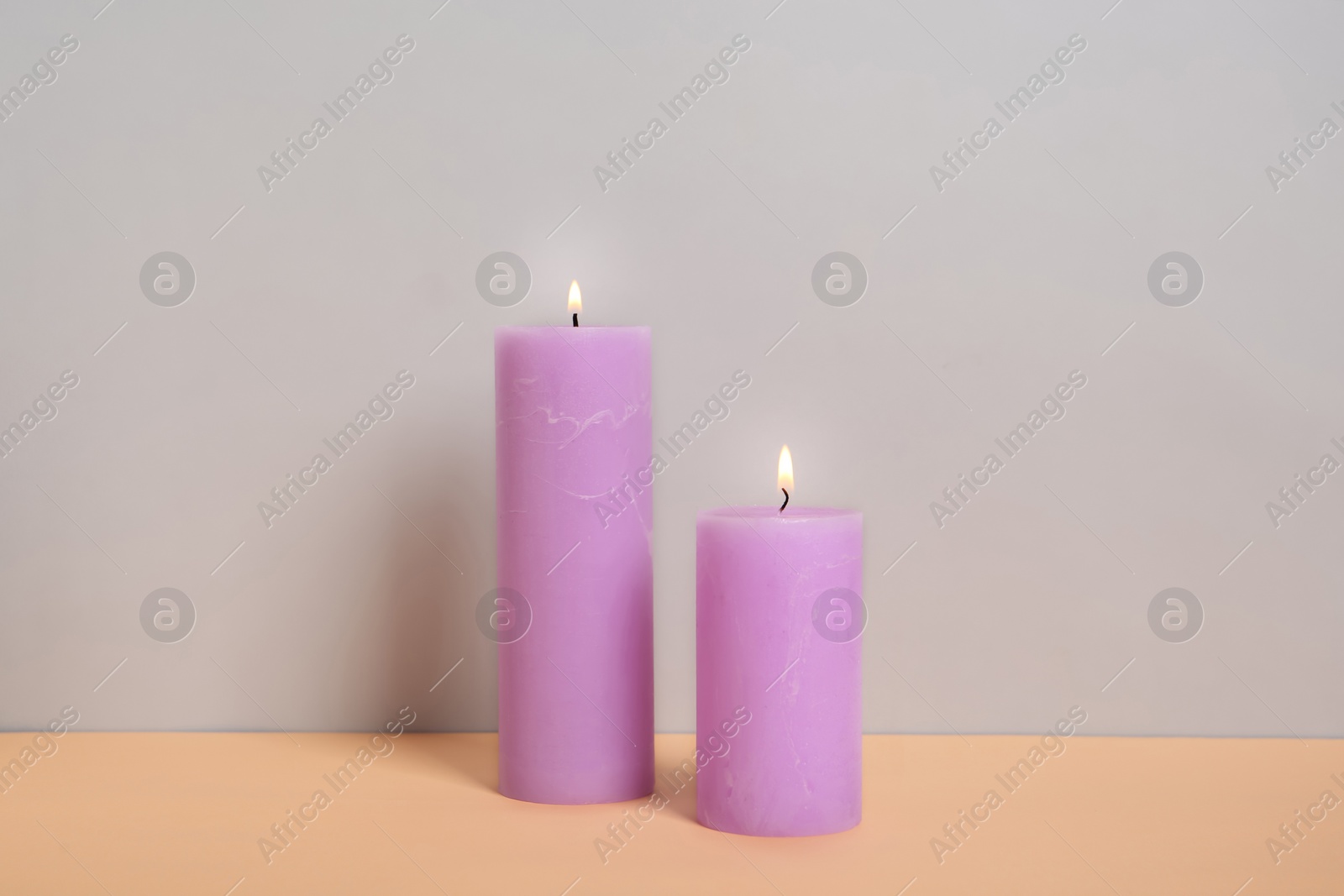 Photo of Decorative candles on table against light background