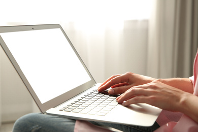 Photo of Woman working with modern laptop indoors, closeup