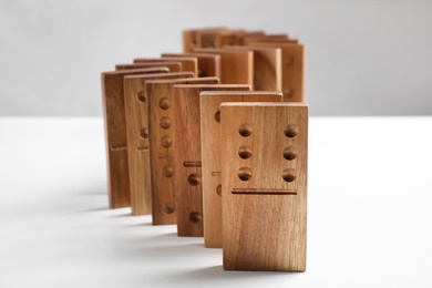 Photo of Beautiful wooden dominoes on white table, closeup