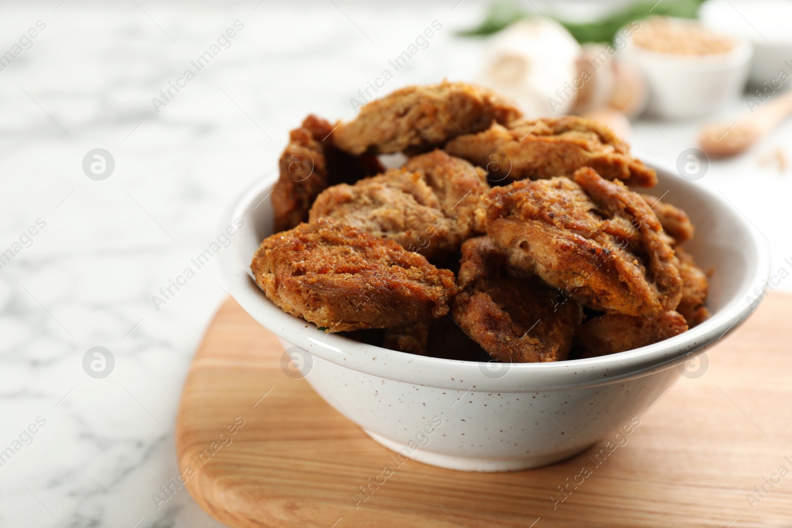 Photo of Delicious cooked soy meat on white marble table, closeup