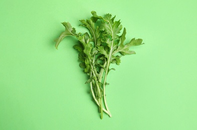 Photo of Fresh arugula on green background, flat lay