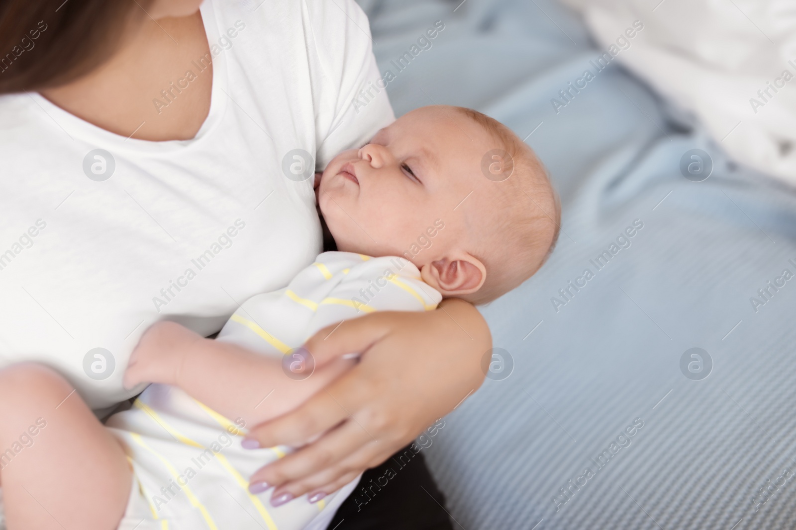 Photo of Mother with her sleeping baby at home, closeup view