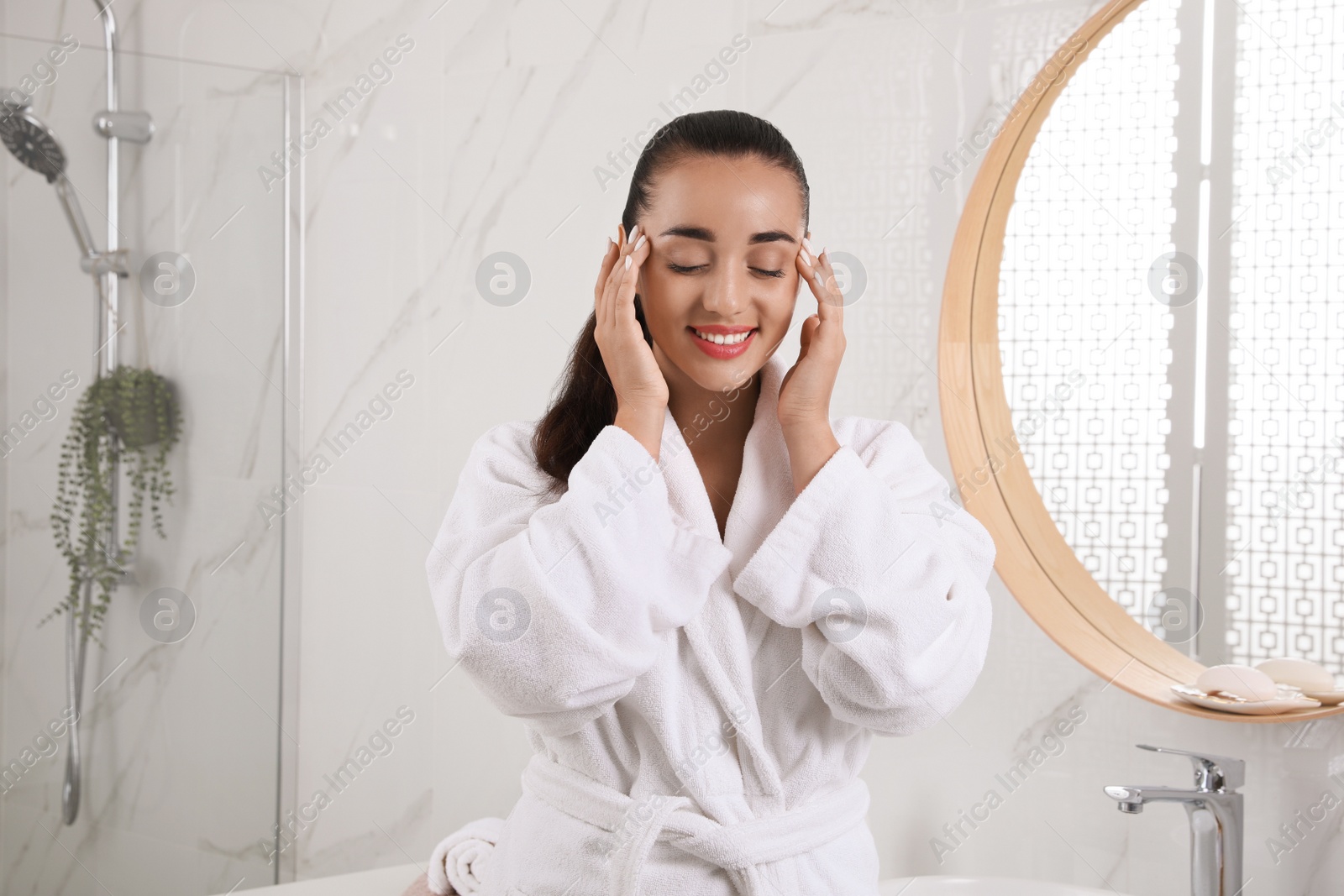 Photo of Beautiful young woman with perfect skin near mirror in bathroom. Facial wash