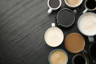 Different coffee drinks in cups on dark textured table, flat lay. Space for text