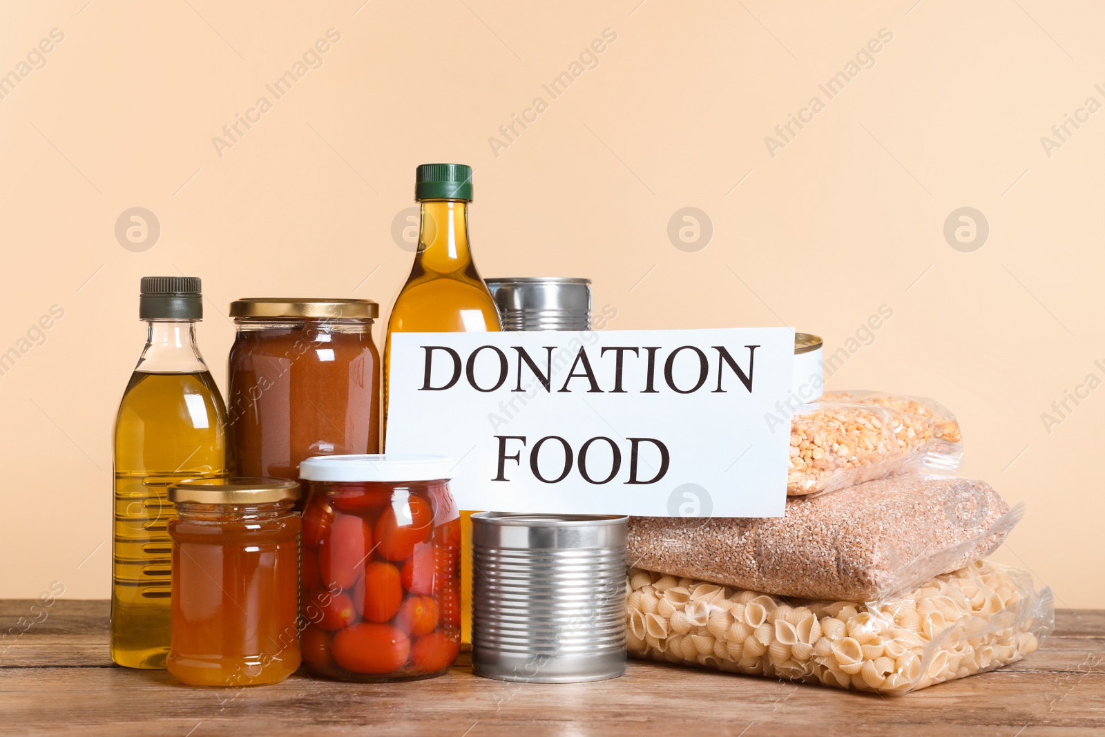 Photo of Card with words Donation Food and different products on wooden table
