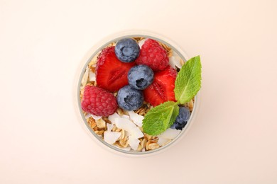 Photo of Tasty oatmeal with berries and mint on beige background, top view. Healthy breakfast