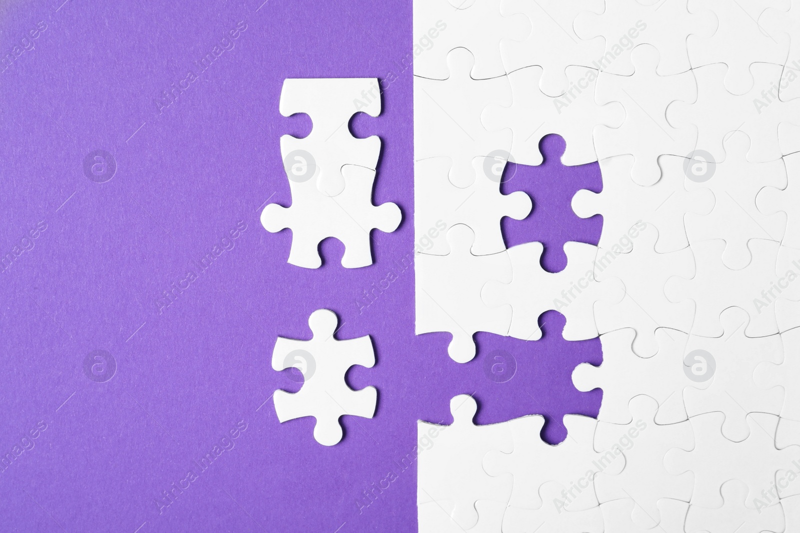 Photo of Blank white puzzle with separated pieces on purple background, flat lay