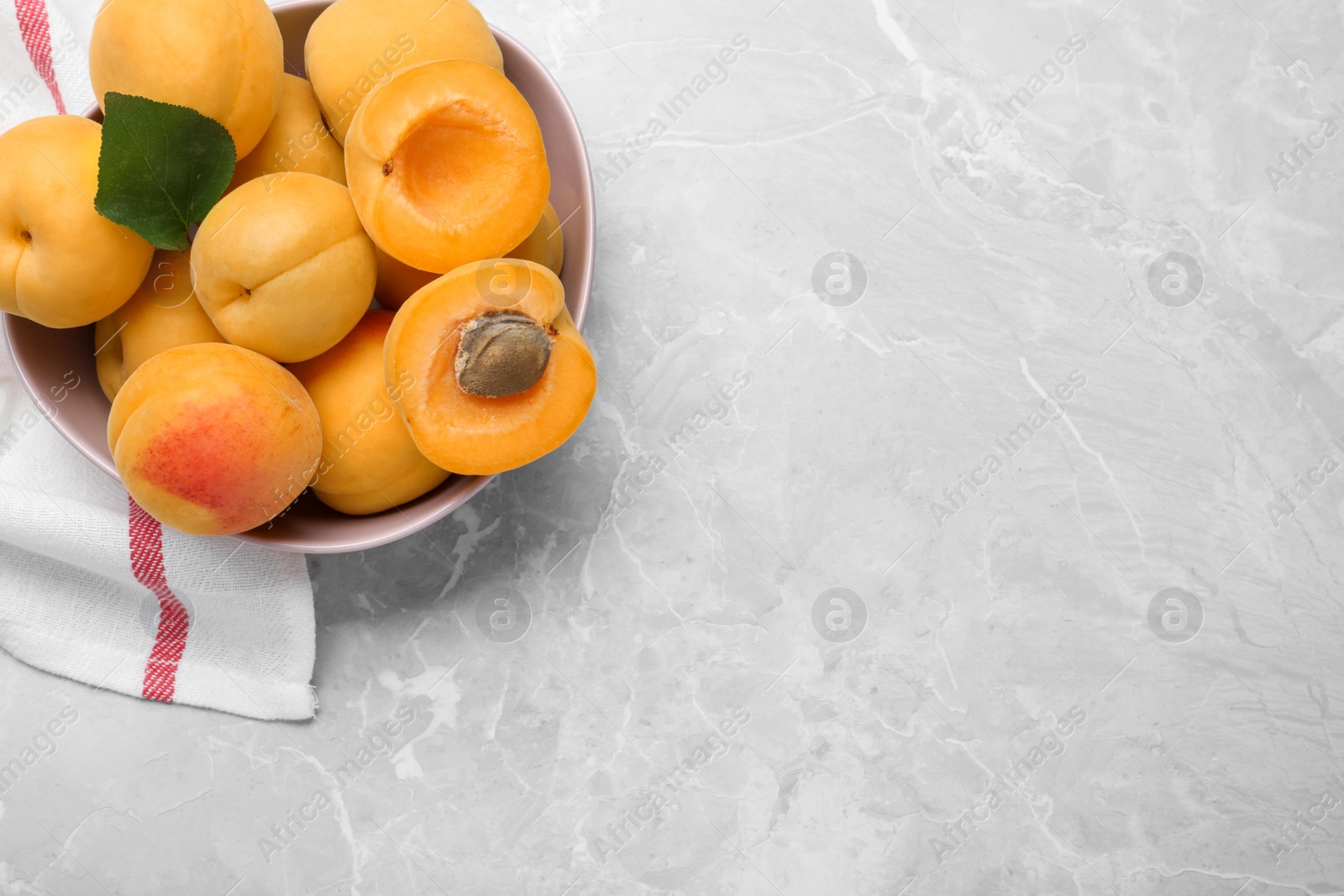 Photo of Delicious fresh ripe apricots on grey marble table, flat lay. Space for text