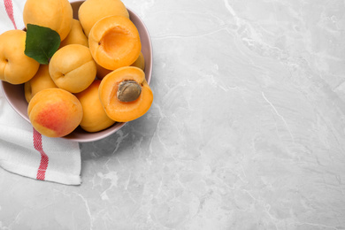 Delicious fresh ripe apricots on grey marble table, flat lay. Space for text