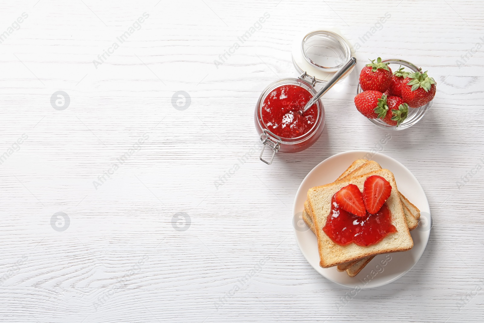 Photo of Flat lay composition with toast bread, strawberry jam and fresh berries on light background