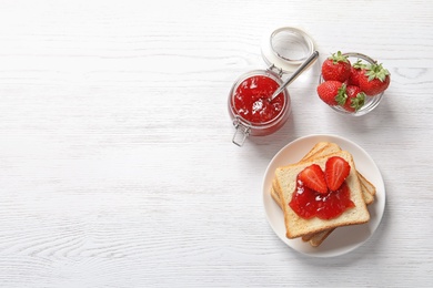 Photo of Flat lay composition with toast bread, strawberry jam and fresh berries on light background