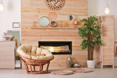Cozy living room interior with comfortable papasan chair and decorative fireplace