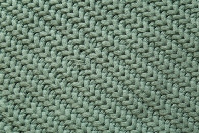 Photo of Beautiful pale green knitted fabric as background, top view