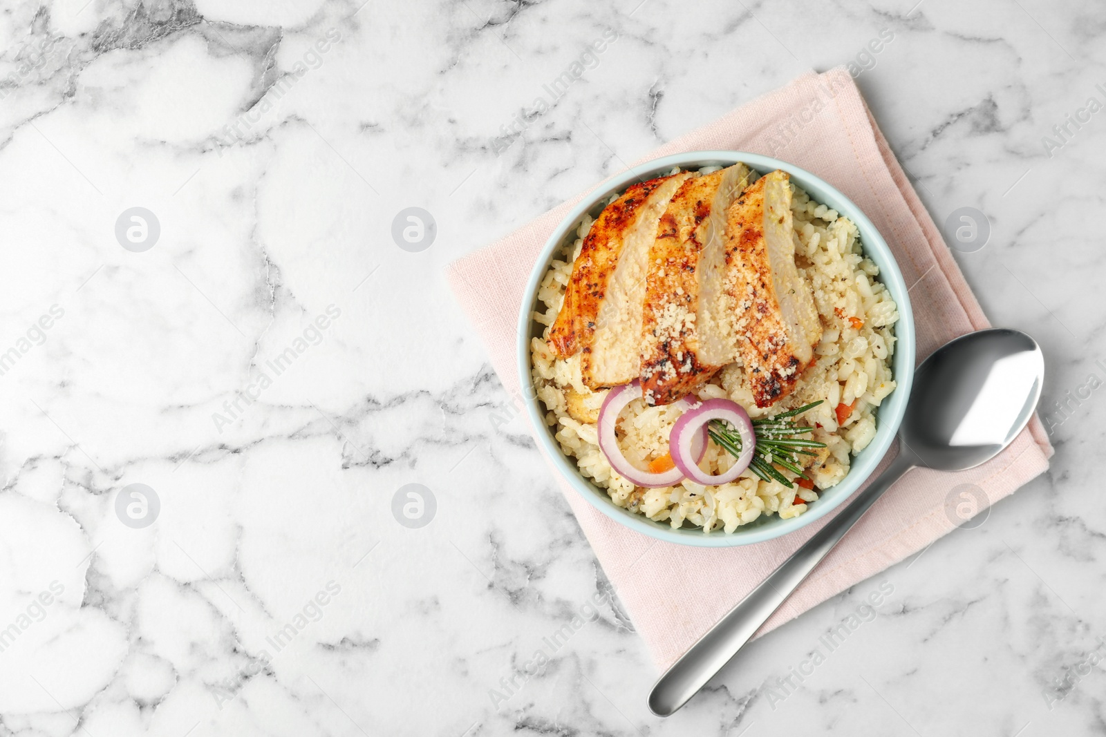 Photo of Delicious chicken risotto served on white marble table, flat lay. Space for text