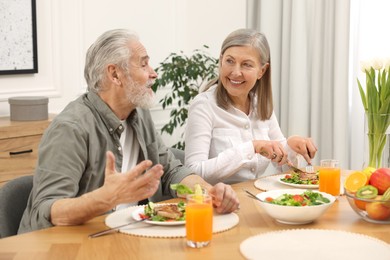 Happy senior couple having dinner at home
