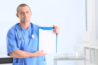 Portrait of medical assistant with stethoscope and clipboard in hospital. Space for text