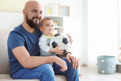 Photo of Dad and his son watching football at home