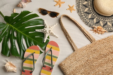 Photo of Different beach accessories on sand, flat lay