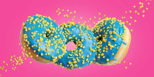 Image of Set of falling delicious donuts on pink background. Banner design