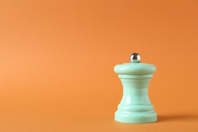 Photo of One turquoise shaker on orange background. Space for text