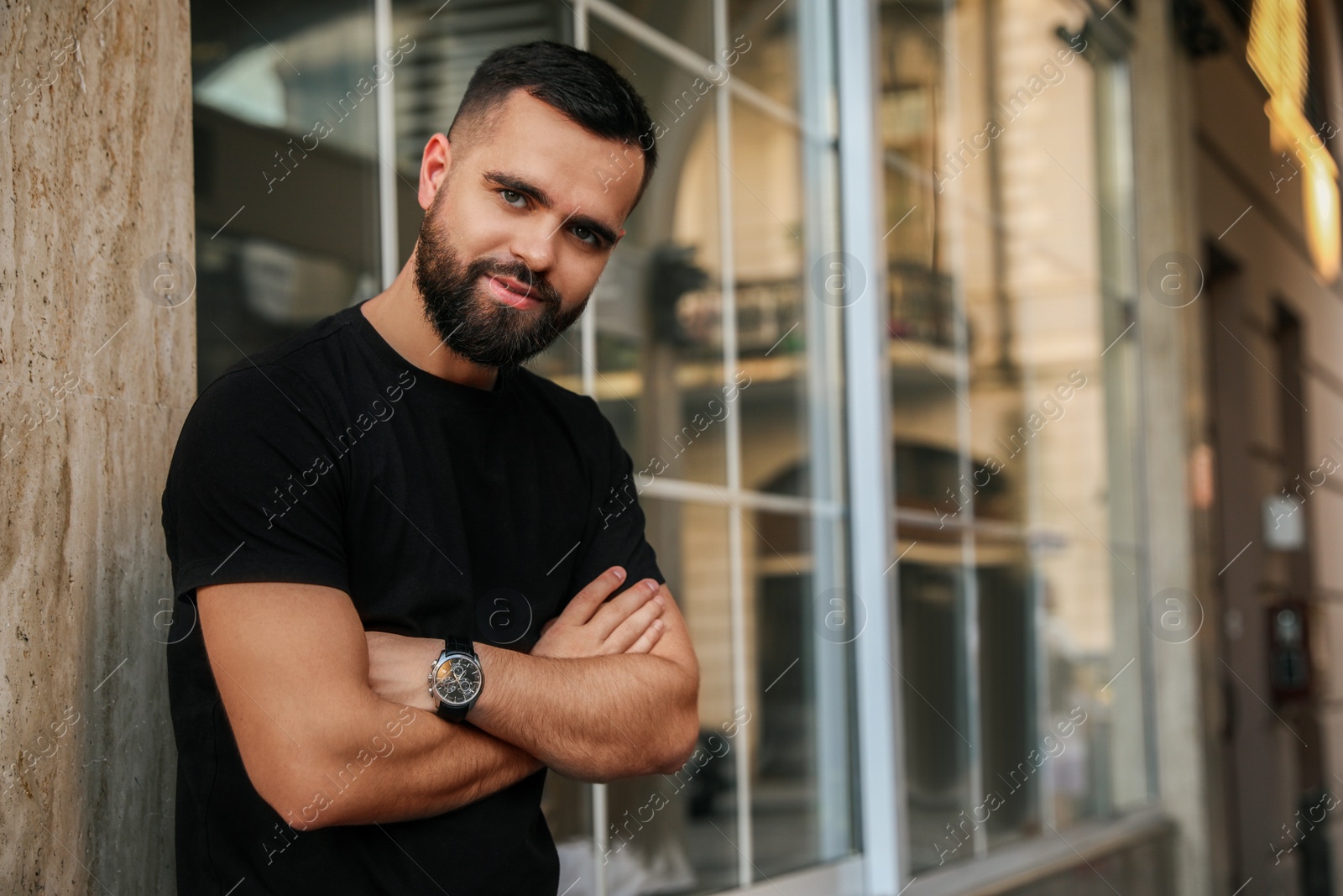 Photo of Portrait of handsome bearded man near building outdoors. Space for text