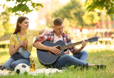 Young couple enjoying picnic in park on summer day