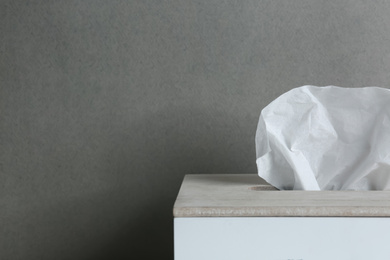 Holder with paper tissues on grey background, closeup. Space for text