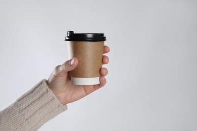 Photo of Woman holding takeaway paper coffee cup on white background, closeup. Space for text