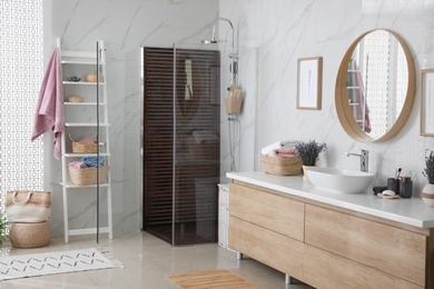 Photo of Bathroom interior with shower stall, counter and shelving unit. Idea for design