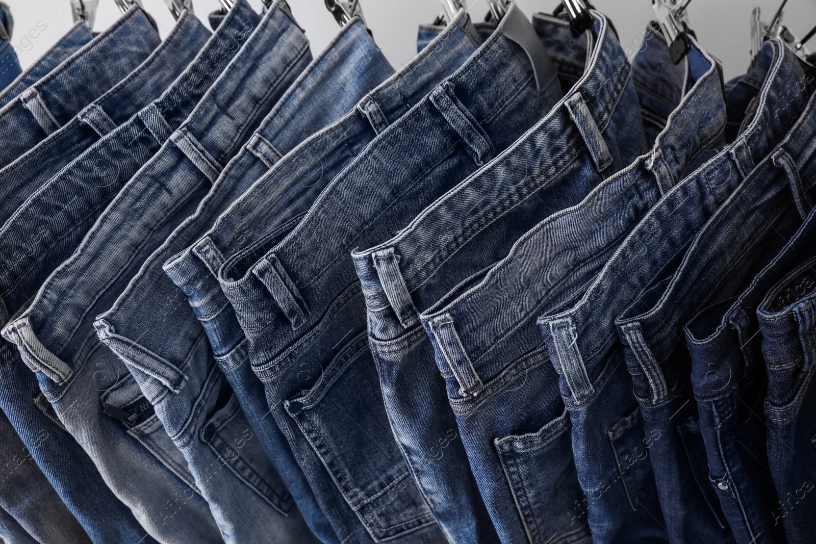 Photo of Closeup view of rack with different jeans