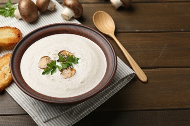 Fresh homemade mushroom soup served on wooden table. Space for text