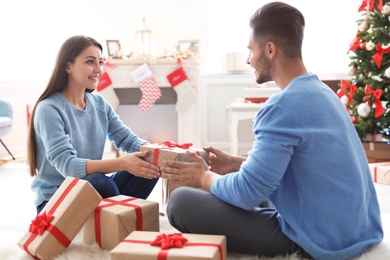 Young couple with Christmas gift at home