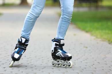 Photo of Woman roller skating on city street, closeup of legs