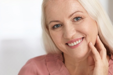 Portrait of beautiful older woman against light background