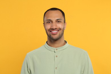 Portrait of handsome young man on orange background