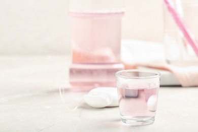 Glass with mouthwash on light table. Teeth care