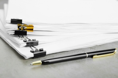 Photo of Stack of documents with binder clips on light table, closeup