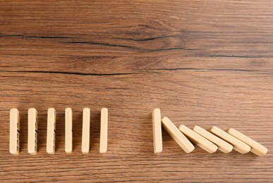 Photo of White domino tiles on wooden background, flat lay. Space for text