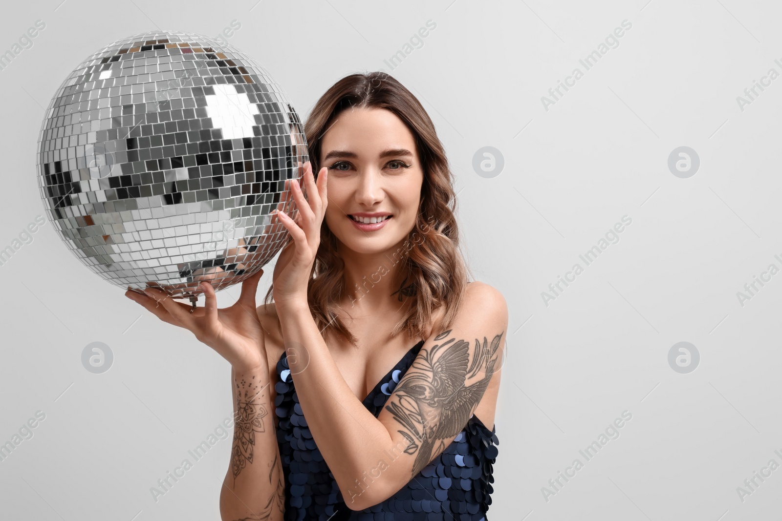 Photo of Beautiful woman with disco ball on white background