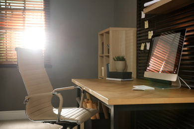 Comfortable workplace with office chair and computer on wooden table