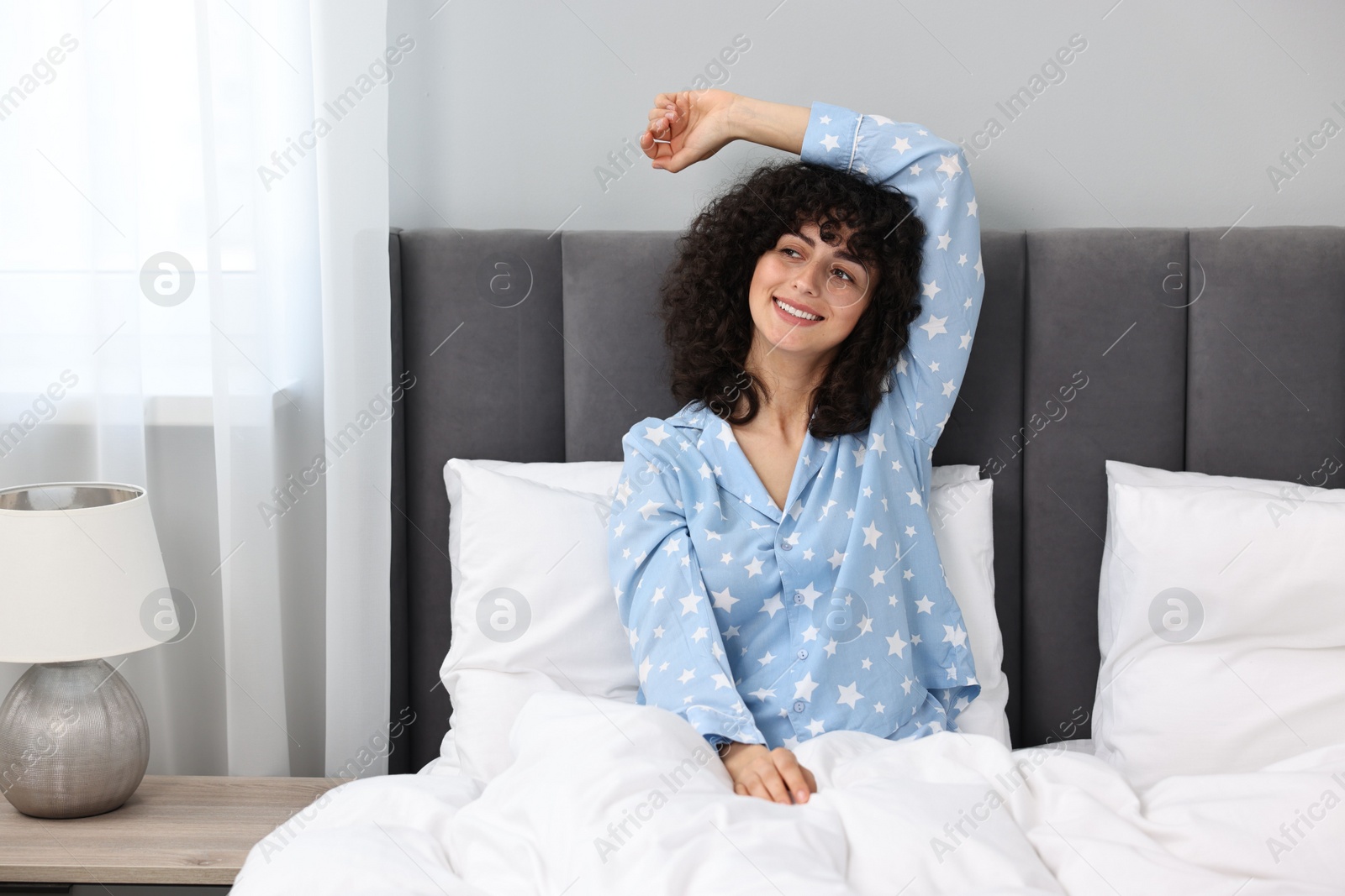 Photo of Beautiful young woman in stylish pyjama in bed at home