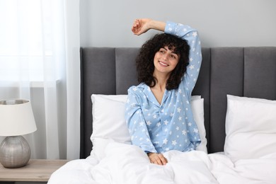Photo of Beautiful young woman in stylish pyjama in bed at home