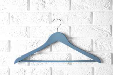 Photo of Empty clothes hanger on brick wall. Wardrobe accessory