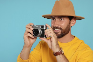 Photo of Man with camera on light blue background. Interesting hobby